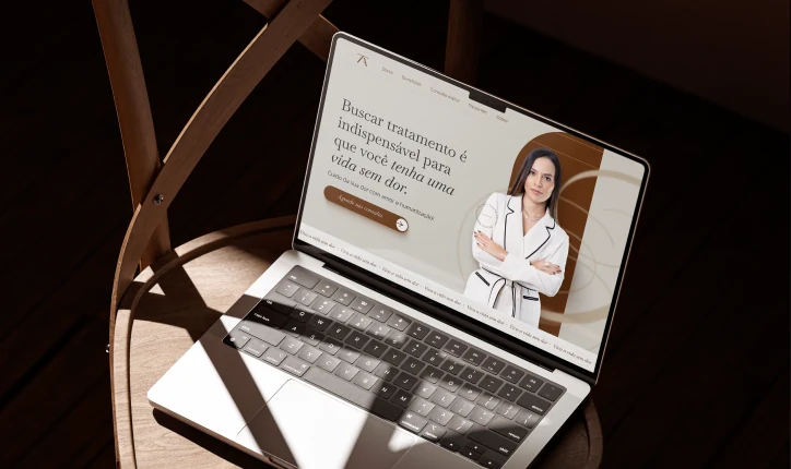 Site da Dra. Taíssa exibido em um notebook apoiado numa cadeira de madeira